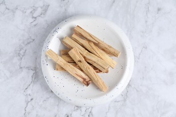 Palo santo sticks on white marble table, top view