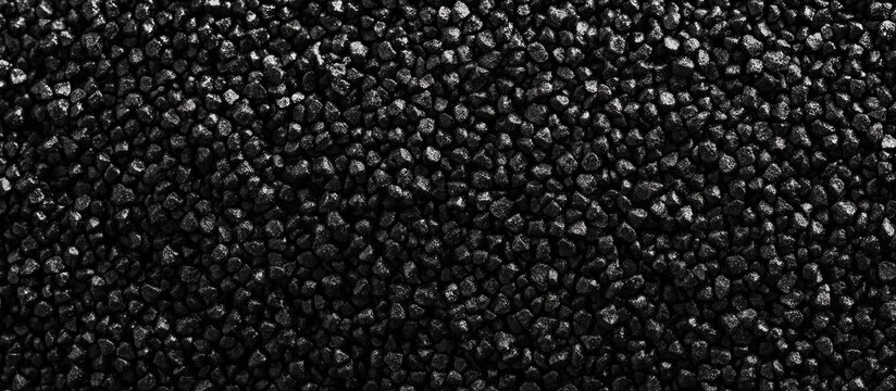Close up view of granulated black polyamide 66 texture with ample copy space for text or graphic design applications