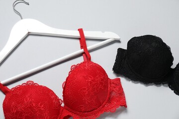 Beautiful lace bras on light background, above view