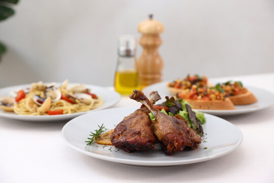 Duck leg confit with sauce. isolate in white background. top view. Duck confit on white plate
