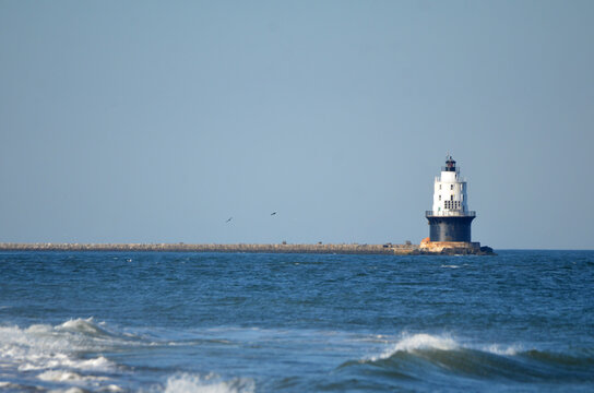 Harbor of Refuge Lighthouse in Cape Henlopen State Park with waves in foreground