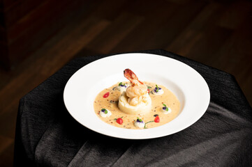 Prawns risotto made with creamy arborio rice and fresh prawns, elegantly served on a white plate with a black and brown background for a rich and sophisticated food presentation.