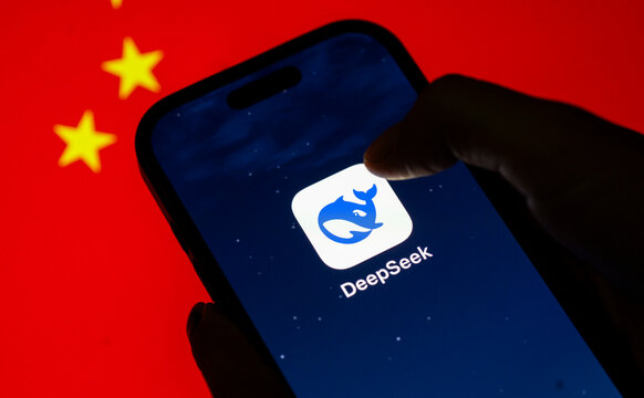 In this photo illustration, the newly launched Chinese DeepSeek app logo is displayed on an iPhone screen in front of displayed Chinese flag.