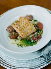 Delightful seafood dish featuring grilled salmon served with roasted vegetables at a dining table