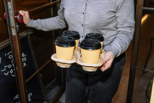 Carrying specialty coffee cups in a cozy cafe setting