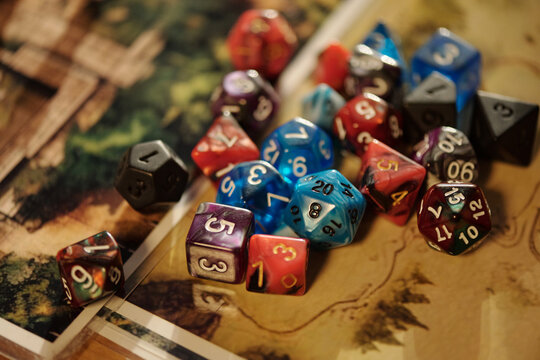 Large group of colorful cube dices with numbers lying on tabletop game pictures or maps prepared for play
