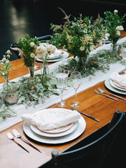 Elegant dinner table setup featuring floral decorations and fine tableware in a modern venue during an evening gathering