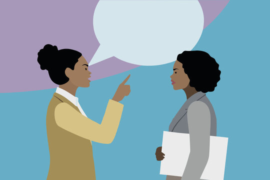 Two businesswomen engage in a serious conversation in a contemporary office