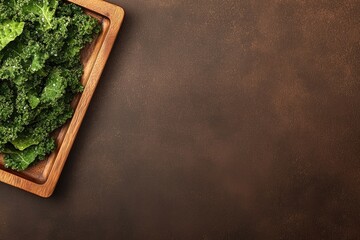 top-down view of elegant wooden tray holding thinly sliced kale chips seasoned with sea salt illuminated by soft natural
