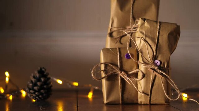 Gift wrapped in brown paper and string with Christmas lights bokeh background