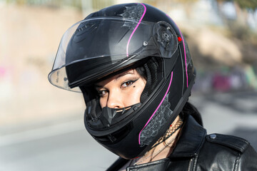 Biker woman wearing modern protective helmet and leather jacket