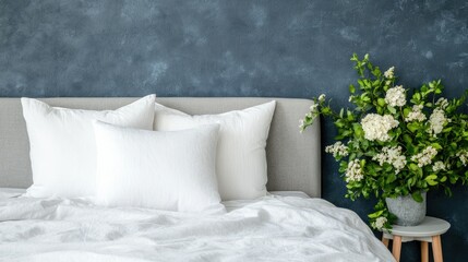 Cozy bedroom with fluffy pillows and a fresh flower arrangement next to a stylish grey headboard in a modern setting
