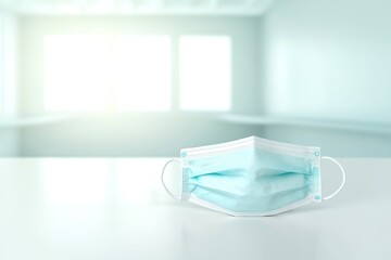 close-up of protective mask and gloves neatly placed on smooth desk under bright light in clinical room