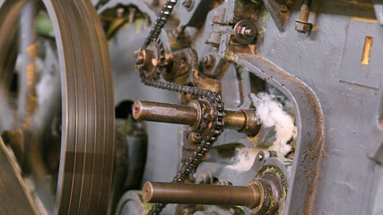 Exploring the intricate workings of a carding machine mechanism in a textile workshop