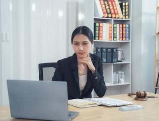 Focused Legal Professional:  A confident female lawyer meticulously examines legal documents on her...