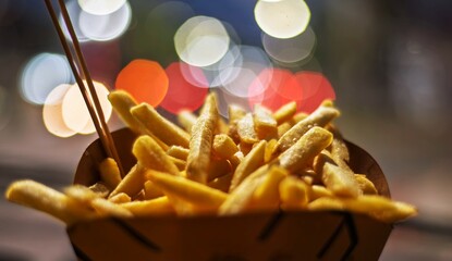 papas fritas en el coche con fondo de bokeh de luces de la ciudad