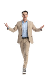 young businessman in beige suit stepping and making welcoming gesture