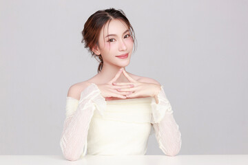 Portraits of young Asian woman K beauty natural makeup face with clean fresh skin on gray...
