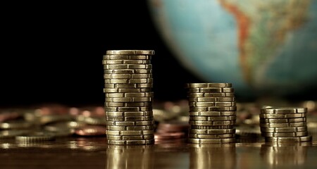 saving coins with money to pay bills having the intention of calculating raising more money to be...