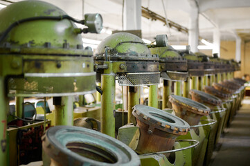 Felt hat presses lined up in a vintage workshop showcasing traditional craftsmanship and industrial charm