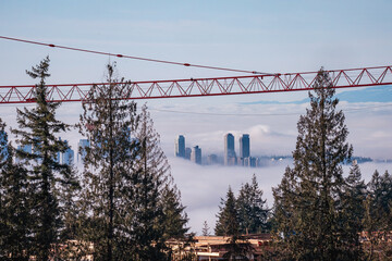 Aerial view of high-rise residential condos partially obscured by cloud inversion over valley as...