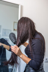 Fototapeta premium Photo of a European girl with long and beautiful brunette hair at the beauty salon. Shiny and healthy hair.