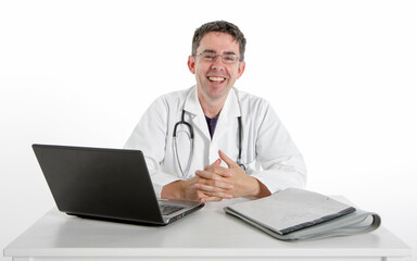 Medical Admin: A Friendly Face. A smiling doctor sitting at his desk with eye contact for the camera, isolated on white.