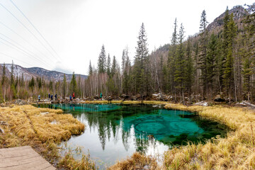  Tourist attraction, Geyser lake with turquoise water in Altai. Siberia, Russia.  Autumn forest,...