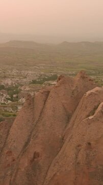 Vertical parorama video. Turkey Travel. Cappadocia's stunning sunset landscape features breathtaking rock formations. Winding road meandering through the picturesque valley. Exciting tourist tour