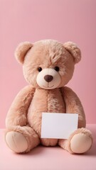 Fototapeta premium A plush teddy bear holding a handwritten love note, sitting on a soft pink background. 