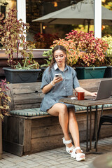 A young girl sits on the street and talks on the phone