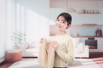 家で洗濯物をたたむ若い女性