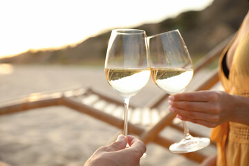 Romantic couple drinking wine together on beach, closeup