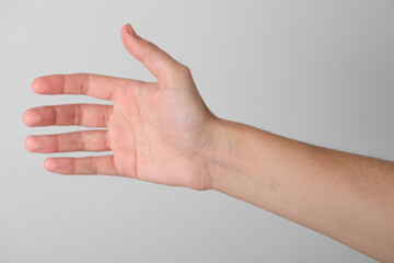 Woman with visible hand veins on light grey background, closeup