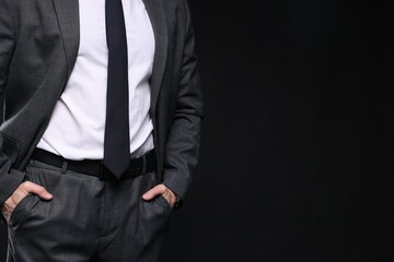 Man in classic suit on black background, closeup. Space for text