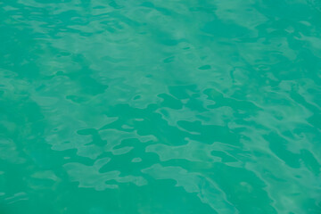 Overhead view of blue water surface abstract. Wave on moving water surface close up in the middle of the screen. Blue ocean water with waves background