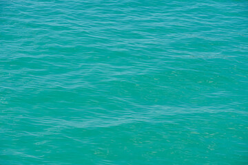 Overhead view of blue water surface abstract. Wave on moving water surface close up in the middle of the screen. Blue ocean water with waves background