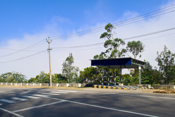 Bus Stop with Clear Blue Sky and Tall Trees