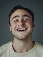 Obraz premium A man with a smile on his face is wearing a yellow shirt. He is looking at the camera and he is happy