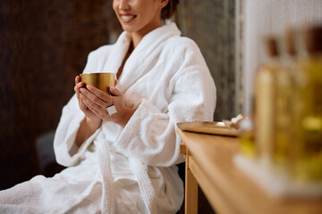 Close up of woman enjoying in cup of tea at health spa.