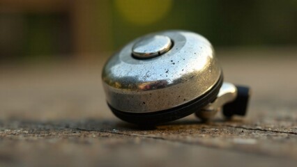 A silver bell is sitting on a wooden surface. The bell is old and rusted, and it is a vintage item. Concept of nostalgia and history