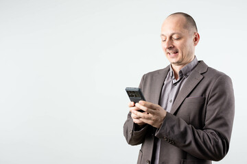 Portrait of a joyful businessman holding mobile phone
