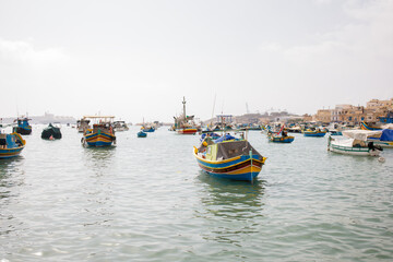 Fototapeta premium Colorful traditional maltese luzzu boats in Marsaxlokk fishers village on Malta