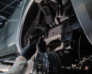 The master sprays an anti-corrosion compound on the bottom of the car.