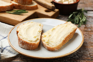Fresh bread with butter on wooden table, closeup