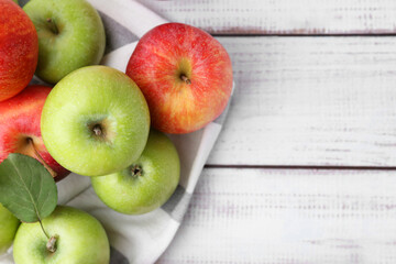 Different whole ripe apples on white wooden table, flat lay. Space for text