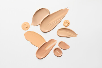 Samples of foundations on white background, top view