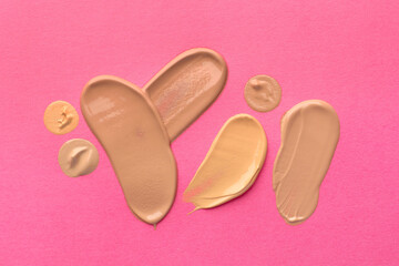 Foundation on pink background, top view. Smears of cosmetic product