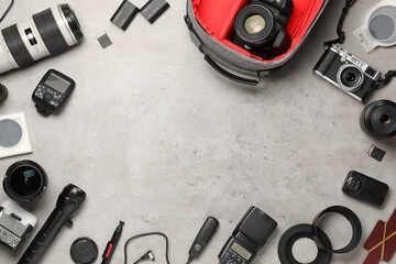 Frame of professional photographer's equipment and backpack on light background, flat lay. Space...