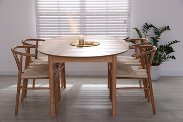 Stylish wooden table with chairs and decor indoors. Interior design